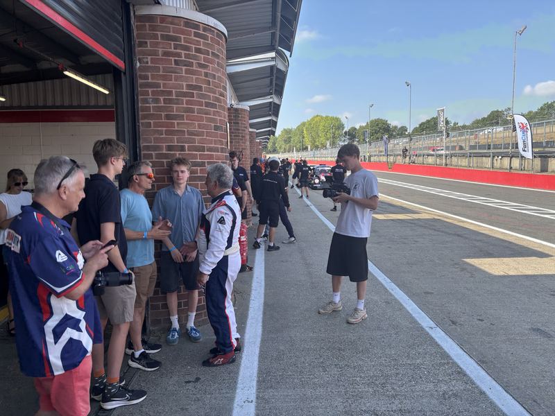 Team members and guests gathered in the pit lane