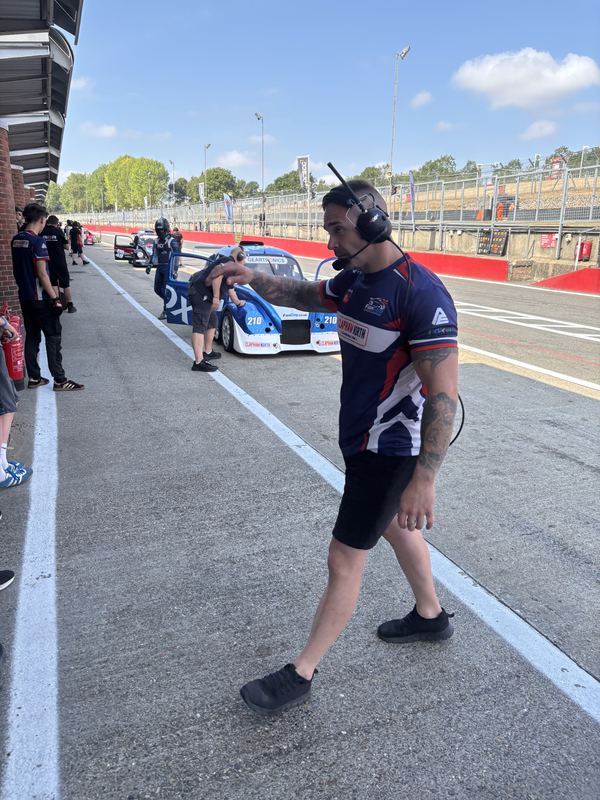 A team member with a radio headset in the pit lane